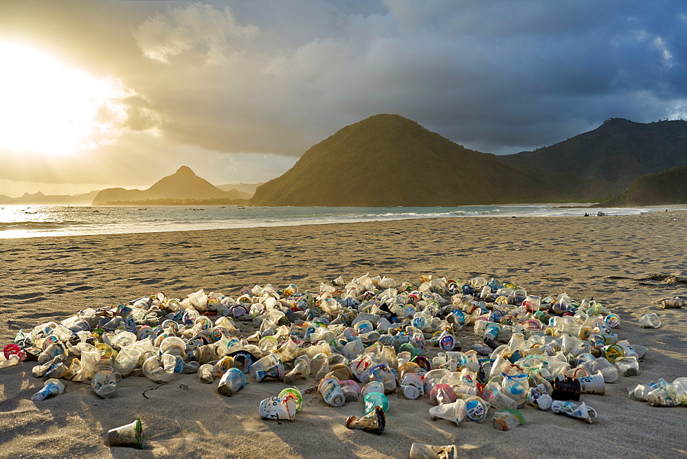 Pile of plastic rubbish dumped on the sand at sunset on Selong Belanak Beach on Lombok, Indonesia, Southeast Asia, Asia