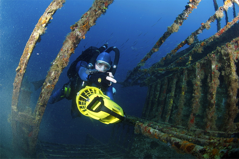 Mixed gas rebreather diver using scooter for mobility inside wreck.  Red Sea.