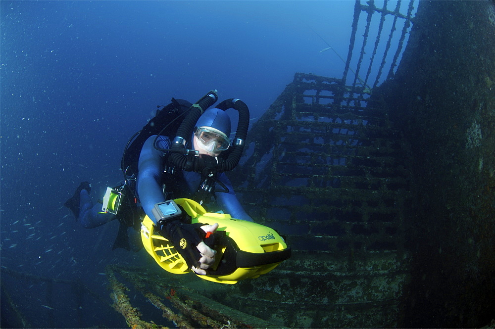 Mixed gas rebreather diver using scooter for mobility around wreck.  Red Sea.