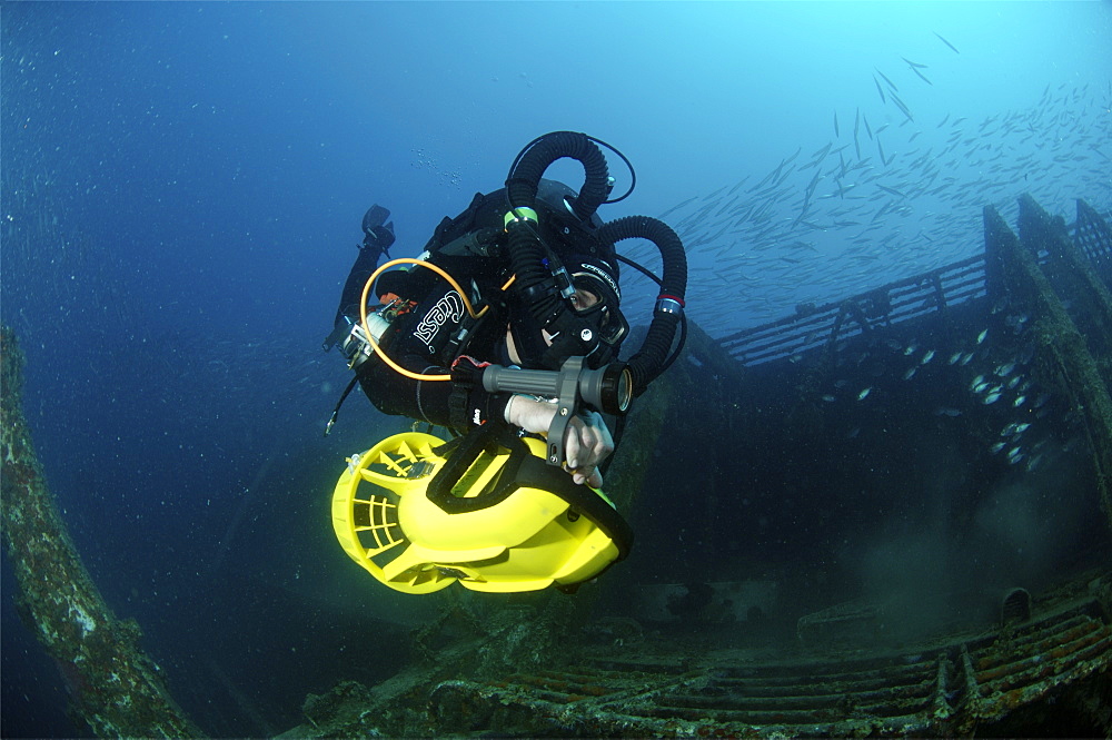 Mixed gas rebreather diver using scooter for mobility around wreck.  Red Sea.