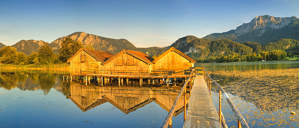 Boathouses at Kochelsee Lake at sunset, Herzogstand and Heimgarten Mountains, Upper Bavaria, Bavaria, Germany, Europe