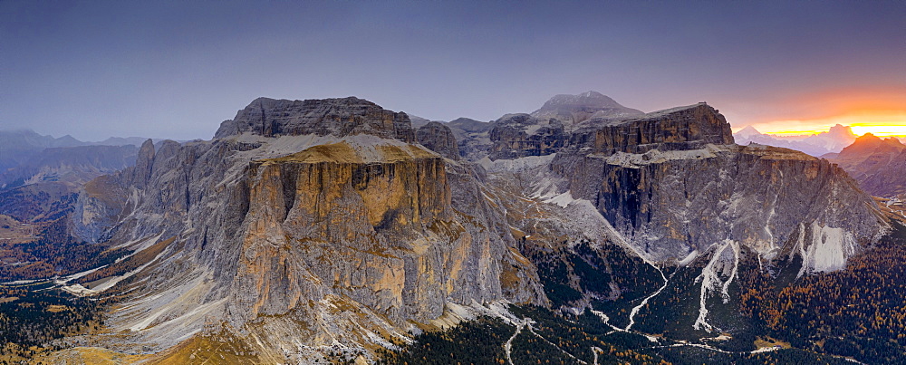 Woods in autumn at foot of Sass Pordoi and Sella mountain at dawn, aerial view, Passo Sella, Dolomites, South Tyrol, Italy, Europe