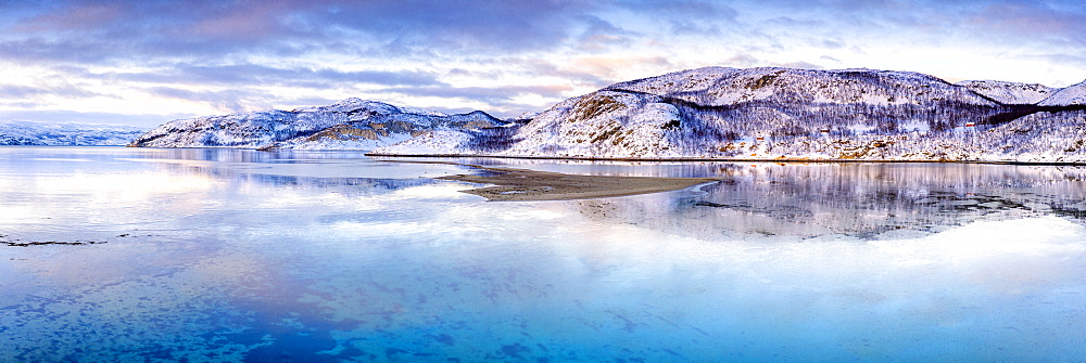 Clouds at sunset on snow capped mountains reflected in the clear water of Laksefjorden, Lebesby, Kunes, Troms og Finnmark, Arctic, Norway, Scandinavia, Europe