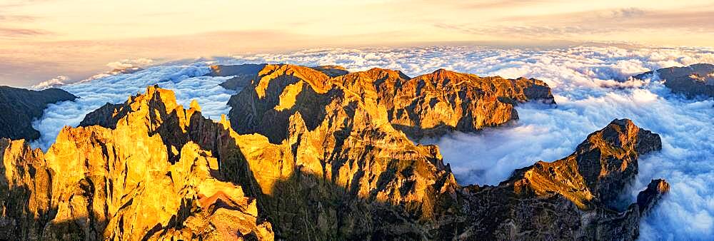 Aerial panoramic of Pico das Torres and Pico do Arieiro mountains in a sea of clouds at sunset, Madeira, Portugal, Atlantic, Europe