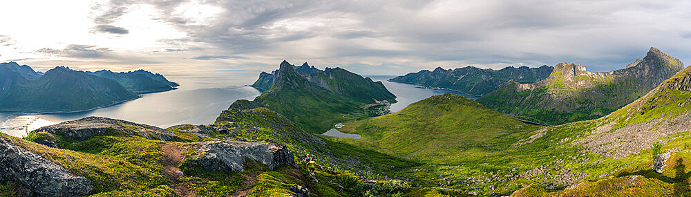 Hikers walking on footpath on Barden mountain above Fjordgard towards Segla peak, Senja island, Troms county, Norway, Scandinavia, Europe