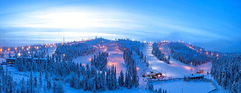 Winter dusk over the snowy ski slopes of Ruka tourist resort, aerial view, Kuusamo, Northern Ostrobothnia, Lapland, Finland