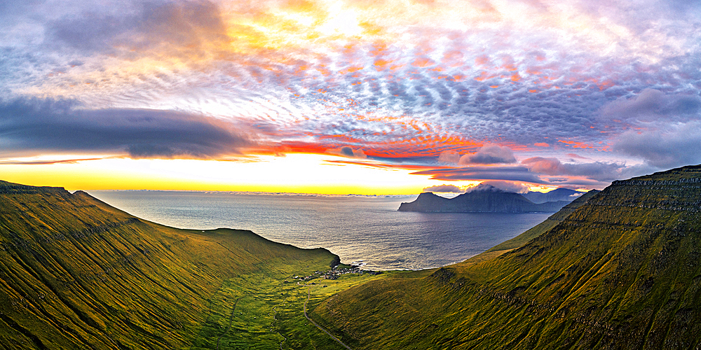 Dramatic sky with clouds at sunrise over the coastal village of Gjogv, aerial view, Eysturoy Island, Faroe Islands, Denmark, Europe