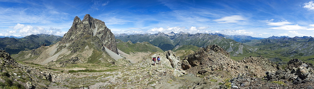 Walkers descend from the top of Pic Peyreget while hiking the GR10 trekking trail, Pyrenees Atlantiques, France, Europe