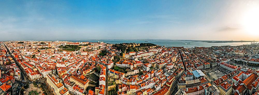 Aerial drone view of Baixa District, facing south towards the Tagus River with the major landmarks visible including St. George Castle, Pantheon, Figueira, Rossio Square, Martim Moniz Squares, Lisbon, Portugal, Europe