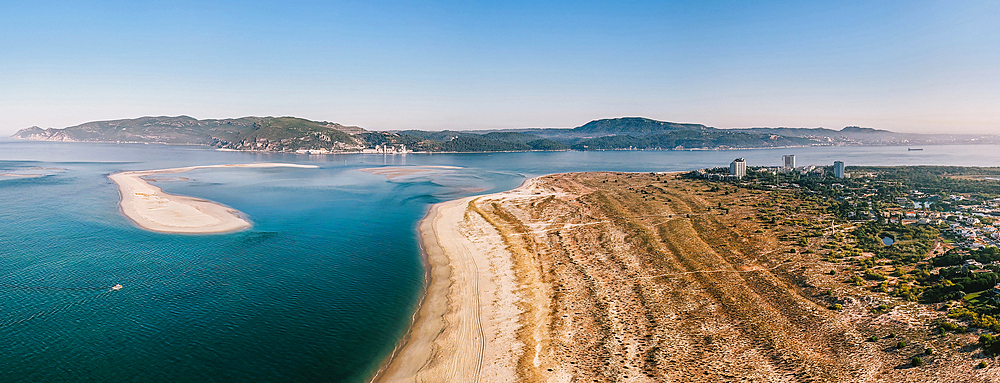 Aerial drone panoramic view of Troia, a peninsula located in Grandola Municipality, next to Sado River estuary, with Arrabida mountain range on left, Alentejo, Portugal, Europe