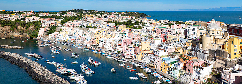 panoramic view of Coricella town, sea and castle on beautiful Procida island with colorful houses in sunny summer day Italy