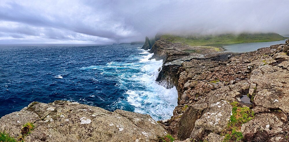 Panorama of Bosdalafossur, a waterfall that flows from the lake directly in the ocean, Faroe Islands, Denmark, Europe