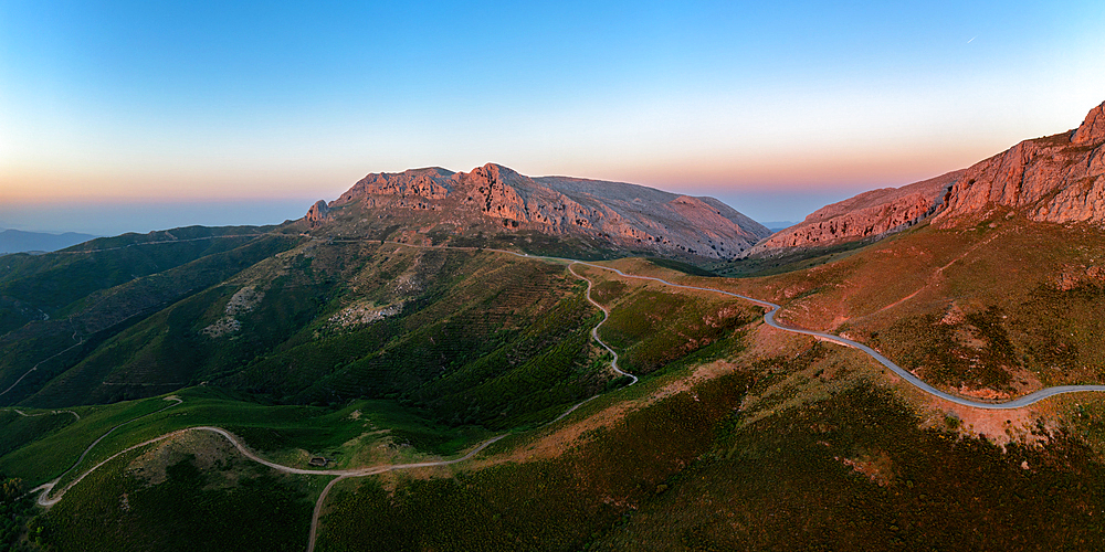 Aerial drone panoramic view of a camper van on a mountain road at sunset, Sardinia, Italy, Mediterranean, Europe