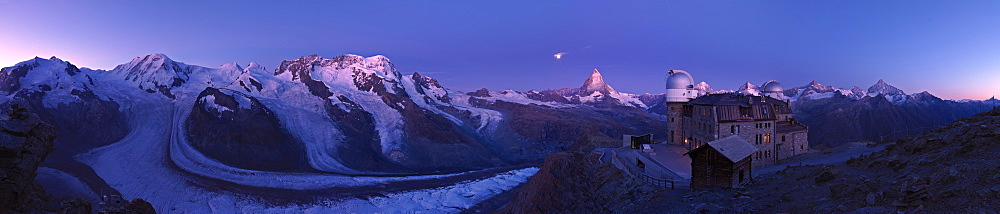 Moon setting at dawn over the Matterhorn, the Gorner Glacier and Kulmhotel at the Gornergrat, Zermatt, Valais, Switzerland, Europe