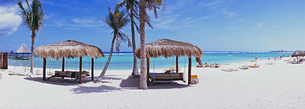 Panorama view of beach and sea with swinging bed under palapas, Mayan Riviera, Akumal, Yucatan, Quintana Roo, Mexico, North America