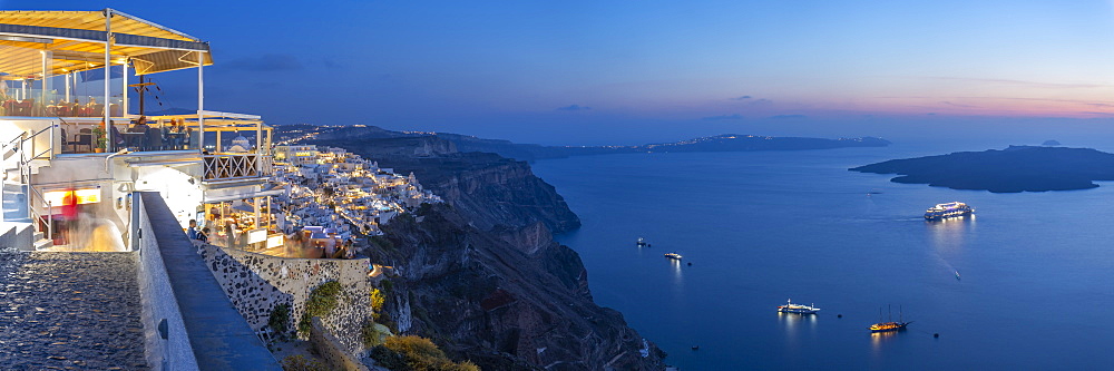 View of Greek restaurant overlooking the Mediterranean Sea at Fira at dusk, Firostefani, Santorini (Thira), Cyclades Islands, Greek Islands, Greece, Europe