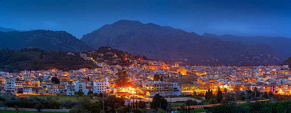 View of churches and rooftops of Pollenca with mountain in background at dusk, Pollenca, Majorca, Balearic Islands, Spain, Mediterranean, Europe