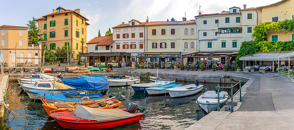 View of boats in the marina and harbourside restaurants during golden hour in Volosko, Opatija, Kvarner Bay, Croatia, Europe