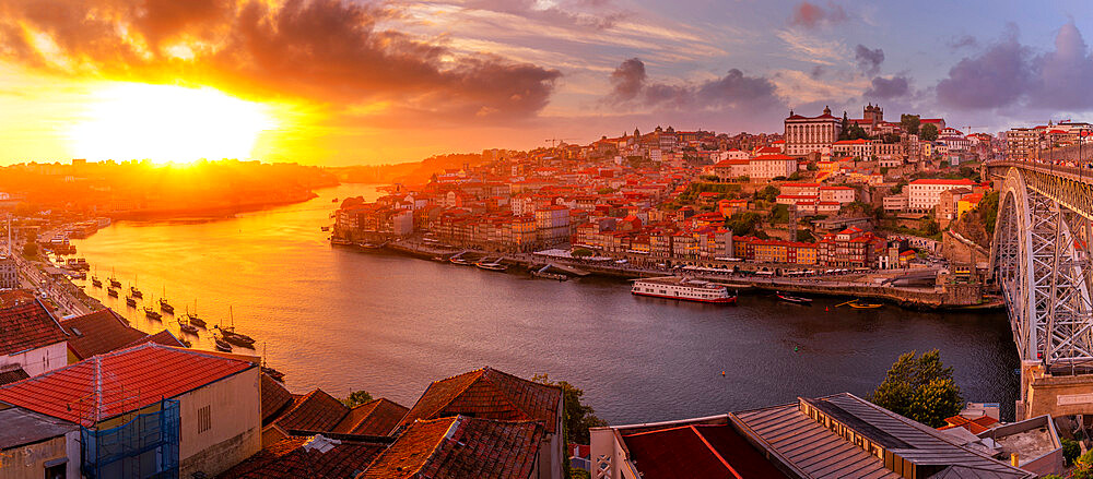 View of the Dom Luis I bridge over Douro River aligned with colourful buildings at sunset, UNESCO World Heritage Site, Porto, Norte, Portugal, Europe