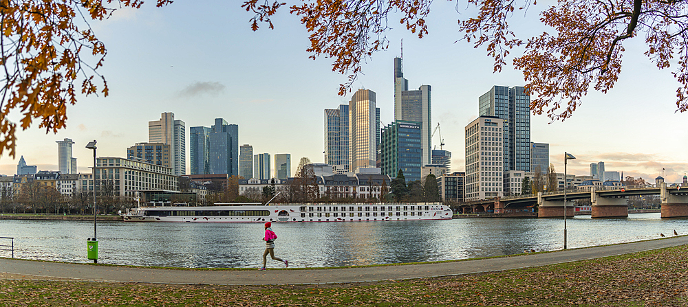 View of city skyline, jogger and River Main at sunset, Frankfurt am Main, Hesse, Germany, Europe