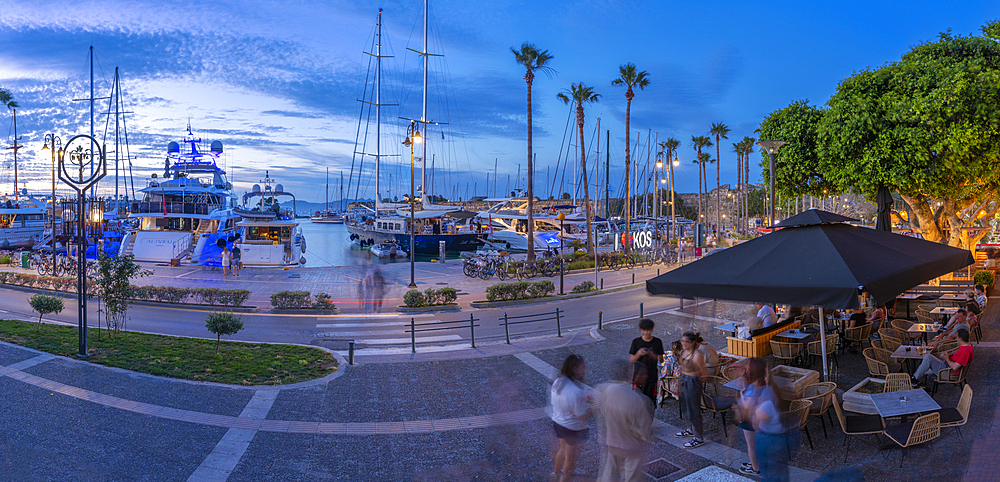 View of cafes and boats in Kos Harbour at dusk, Kos Town, Kos, Dodecanese, Greek Islands, Greece, Europe