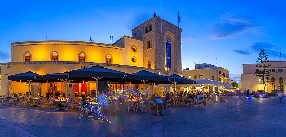 View of cafe and restaurant in Eleftherias Central Square in Kos Town at dusk, Kos, Dodecanese, Greek Islands, Greece, Europe