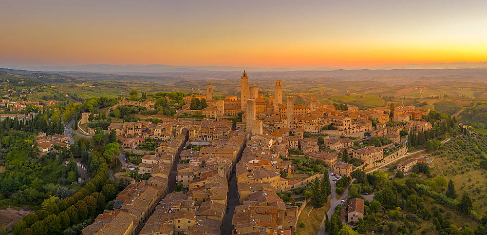 Elevated view of rooftops and town at sunrise, San Gimignano, Tuscany, Italy, Europe