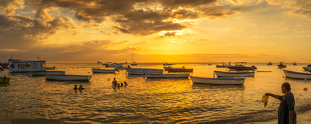 View of boats and people on Mon Choisy Public Beach at sunset, Mauritius, Indian Ocean, Africa