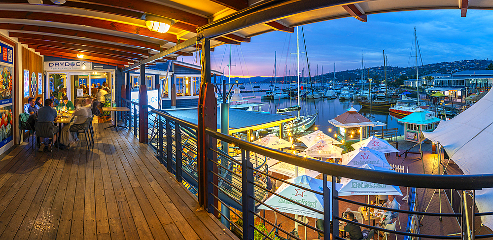 View of boats and restaurants at Knysna Waterfront at dusk, Knysna, Western Cape Province, South Africa, Africa