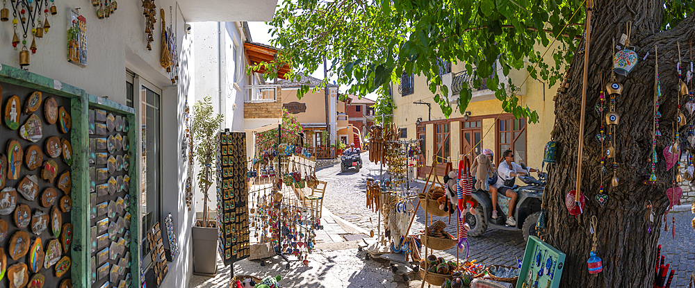 View of souvenir shop and couple on quad bike in Theologos, Theologos, Thassos, Aegean Sea, Greek Islands, Greece, Europe