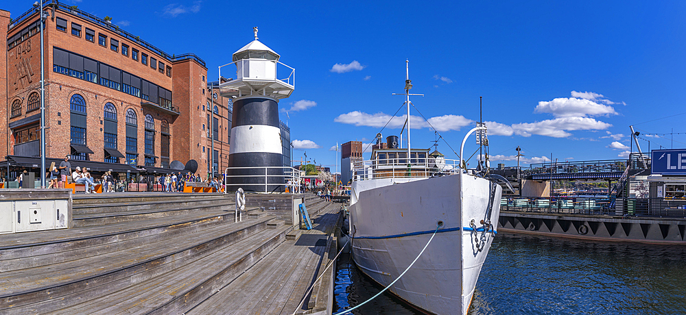 View of waterfront cafes and Oslo Lighthouse, Aker Brygge, Oslo, Norway, Scandinavia, Europe