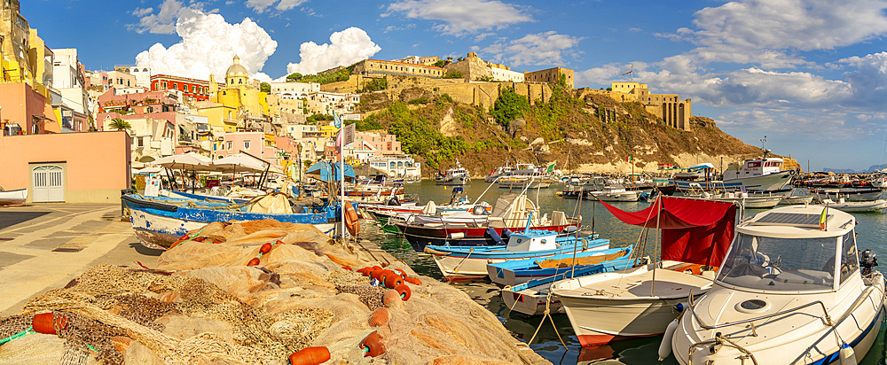 View of fishing nets, boats in Marina di Corricella and Eglise Santa Maria delle Grazie in background, Procida, Phlegraean Islands, Gulf of Naples, Campania, Southern Italy, Italy, Europe