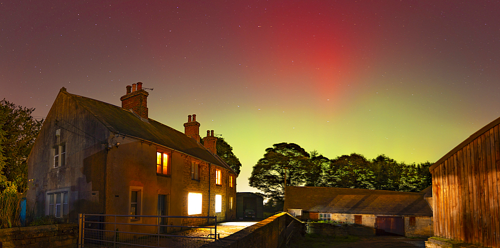 View of Northern Lights (Aurora borealis) and farmhouse near the village of Glapwell, Bolsover, Derbyshire, England, United Kingdom, Europe