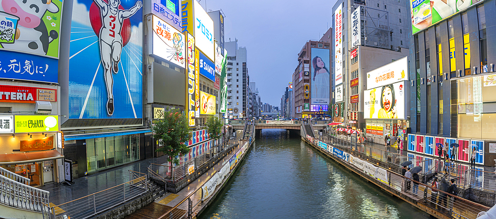 View of colourful adverts in Dotonbori, vibrant entertainment district near the river at dusk, Osaka, Honshu, Japan