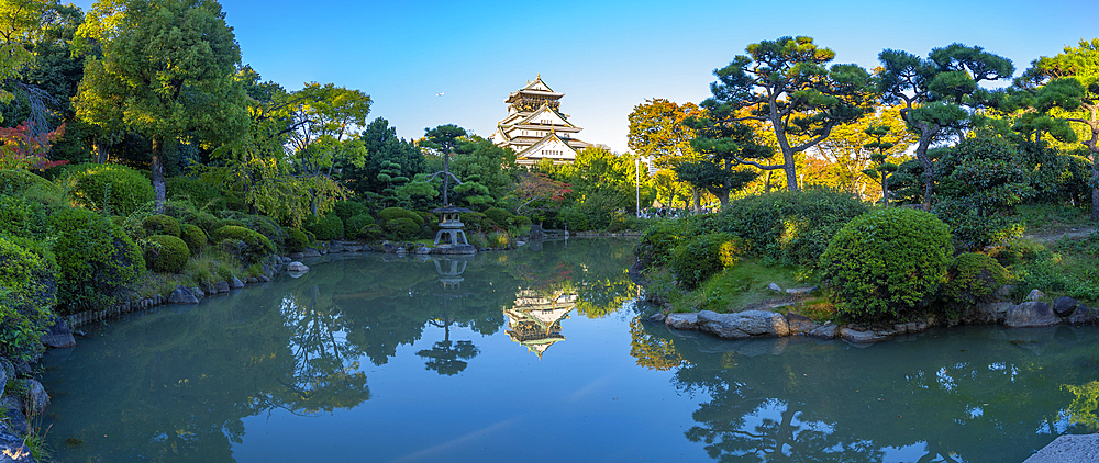 View of Osaka Castle reflecting in Japanese garden pond at sunset, Osakajo, Chuo Ward, Osaka, Honshu, Japan, Asia