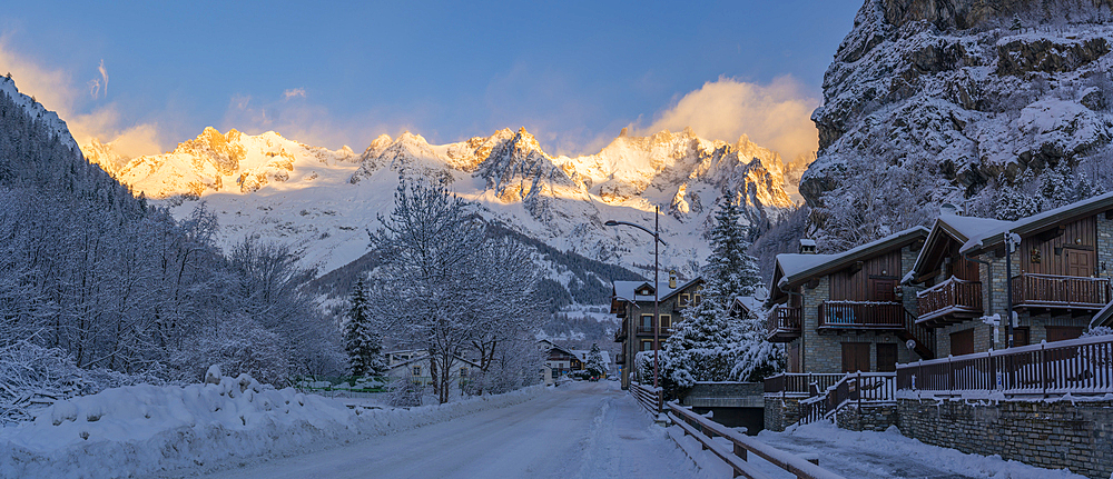 View of hotels, chalets and snow covered mountains in Courmayeur at sunrise during winter, Courmayeur, Aosta Valley, Italy, Europe