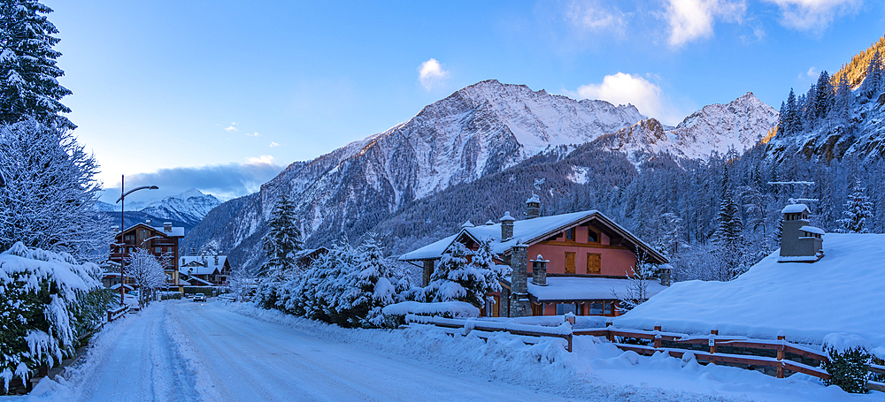 View of hotels, chalets and snow covered mountains in Courmayeur at sunrise during winter, Courmayeur, Aosta Valley, Italy, Europe