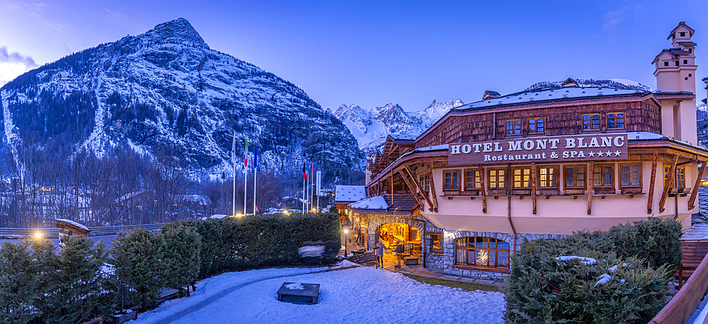 View of snow covered mountains and hotel in Courmayeur at dusk in winter, Courmayeur, Aosta Valley, Italy, Europe