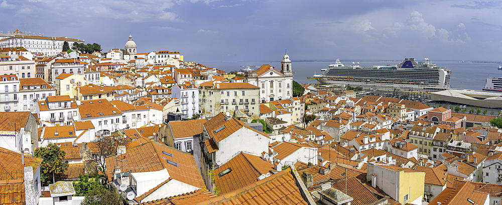 View of cruise ship in port and terrakotta rooftops in Alfama, Alfama District, Lisbon, Portugal, Europe