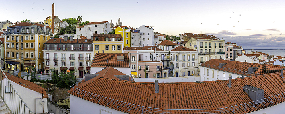 View of colourful buildings and red rooftops at sunset in the Alfama District, Lisbon, Portugal, Europe