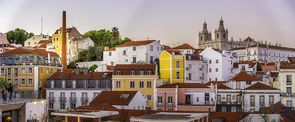 View of colourful buildings and red rooftops at sunset in the Alfama District, Lisbon, Portugal, Europe