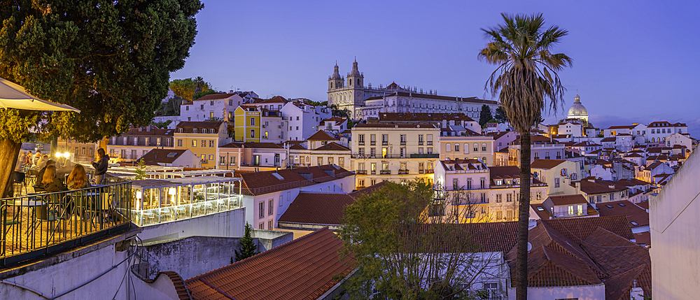 View of colourful buildings and red rooftops at dusk in the Alfama District, Lisbon, Portugal, Europe