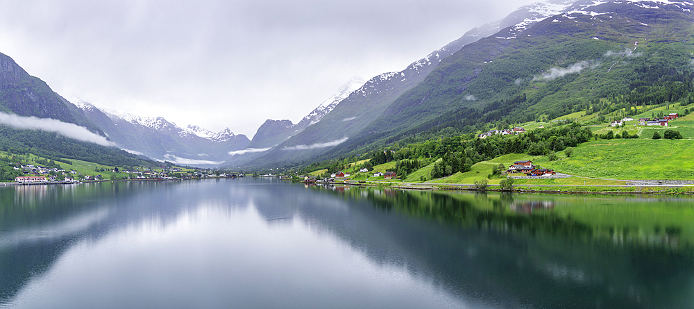 View of Olden village and mountains reflecting in Nordfjorden during summer, Norway, Scandinavia, Europe