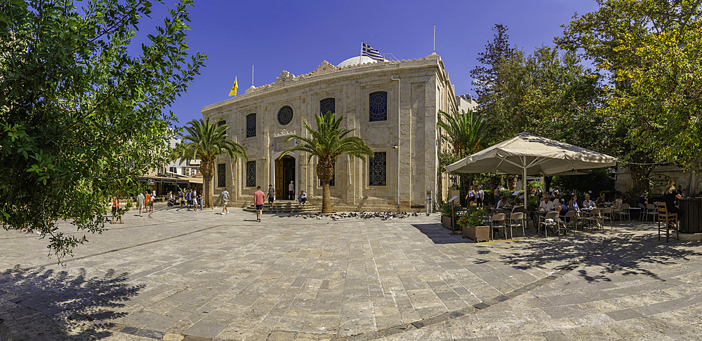 View of Cathedral Holy Temple of Saint Titus and cafe on a sunny day, City of Heraklion, Crete, Greek Islands, Geece, Europe