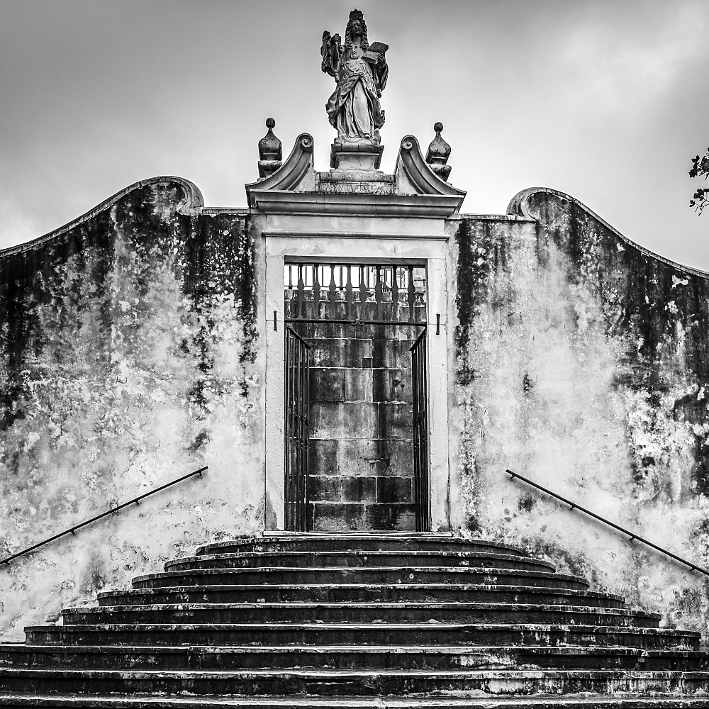 Weathered building exterior with statue above doorway, Coimbra, Coimbra District, Portugal