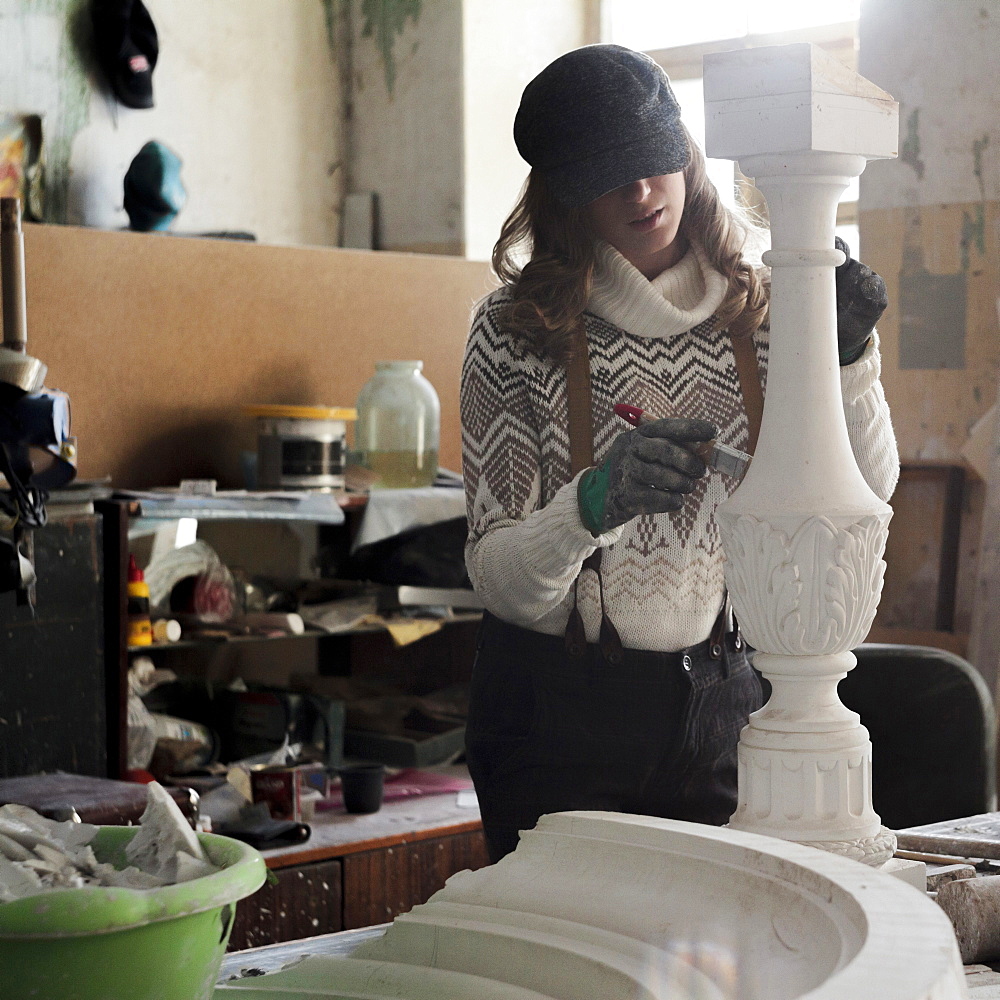 Caucasian artist sculpting with tool