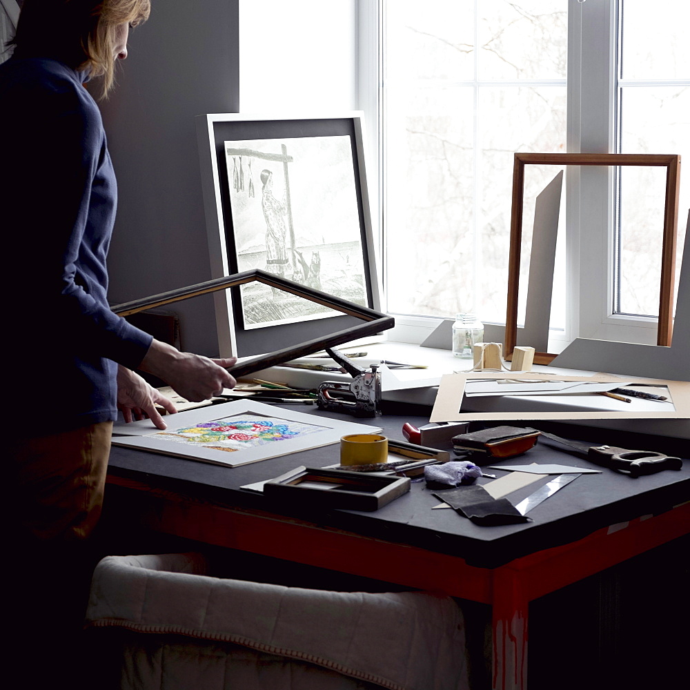 Caucasian woman holding picture frame at table