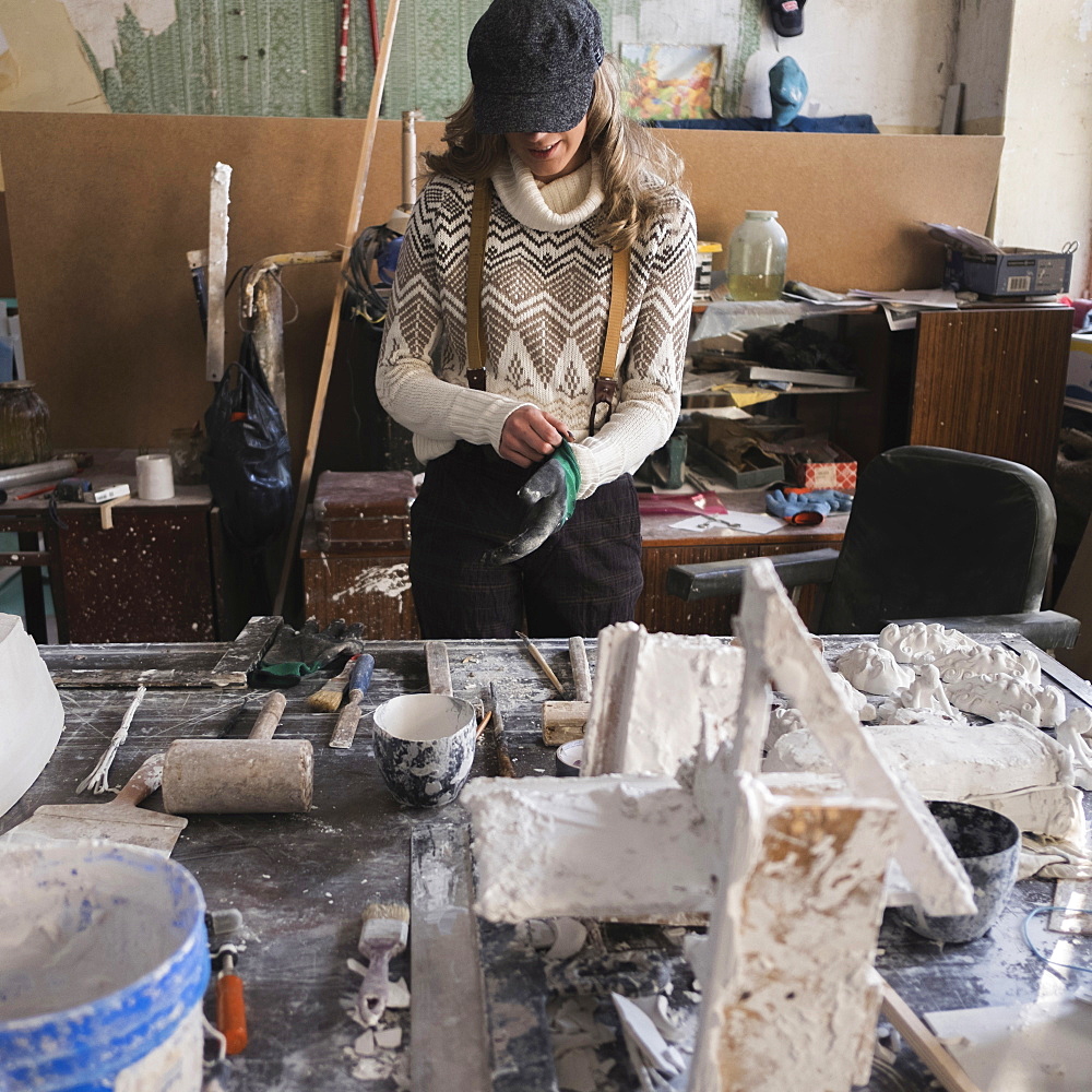 Caucasian sculptor preparing with glove