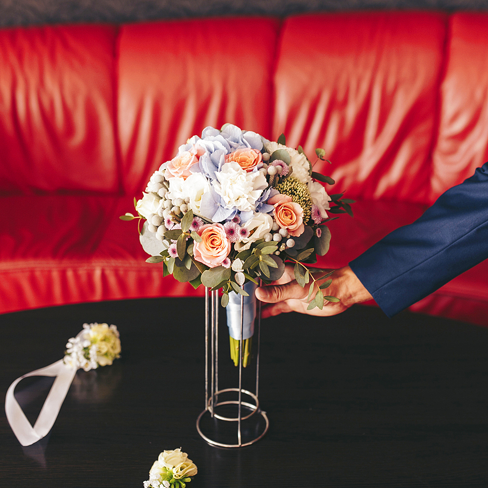 Caucasian man placing bouquet of flowers on table