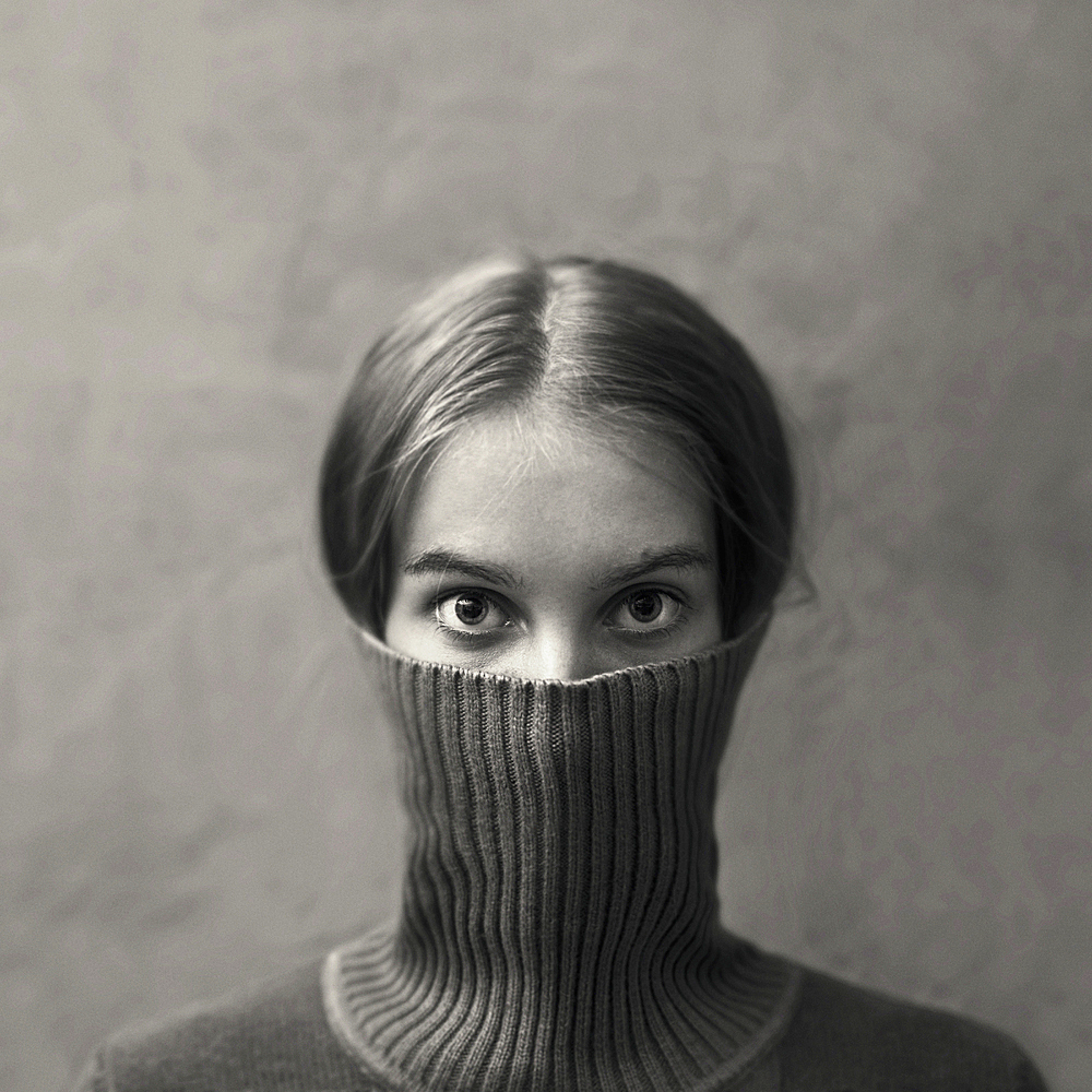 Caucasian girl hiding face in turtleneck